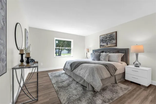 a spacious bedroom with a bed a mirror and a window