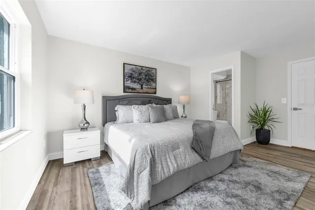 a bedroom with a large bed and a potted plant