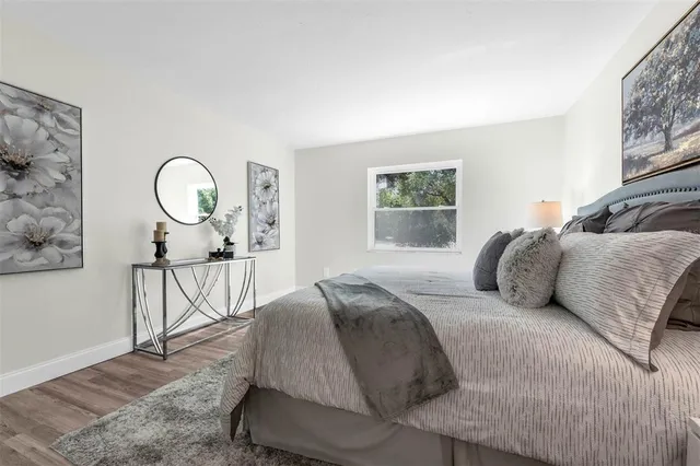 a bedroom with a bed a chandelier with the wooden floor