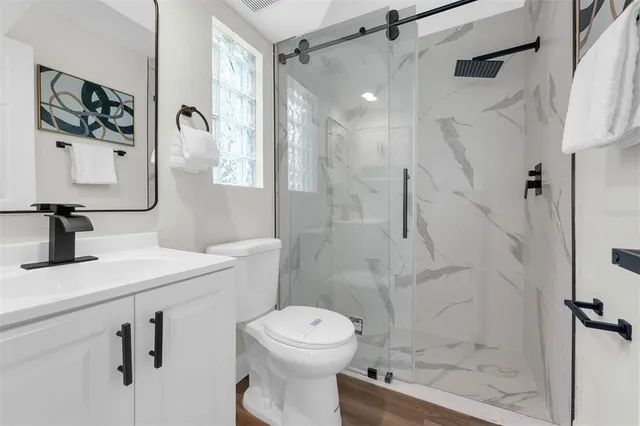 a bathroom with a sink a toilet and shower