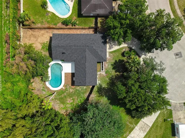 an aerial view of a house with a swimming pool and garden