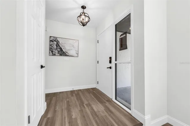 a view of a hallway with wooden floor and closet