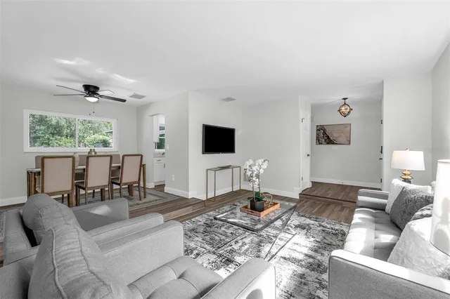 a living room with furniture wooden floor and a flat screen tv