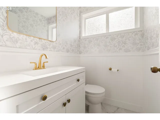 a bathroom with a sink a toilet and a mirror