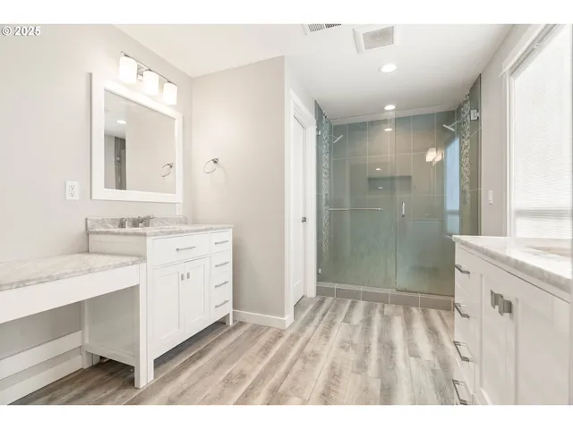 a bathroom with a sink a mirror a shower and a mirror