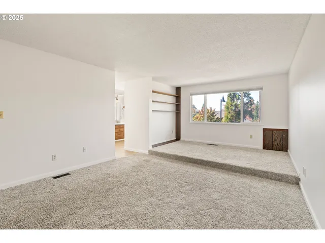 a view of empty room with a fireplace and wooden floor