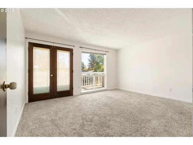 a view of a big room with windows and chandelier fan