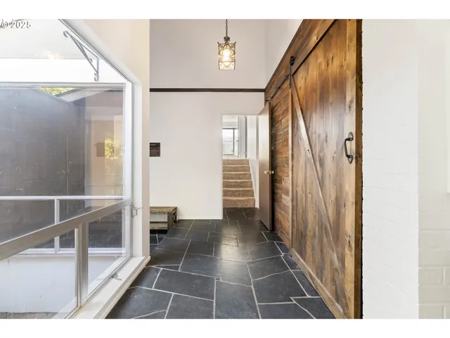 a view of a hallway with wooden floor and staircase