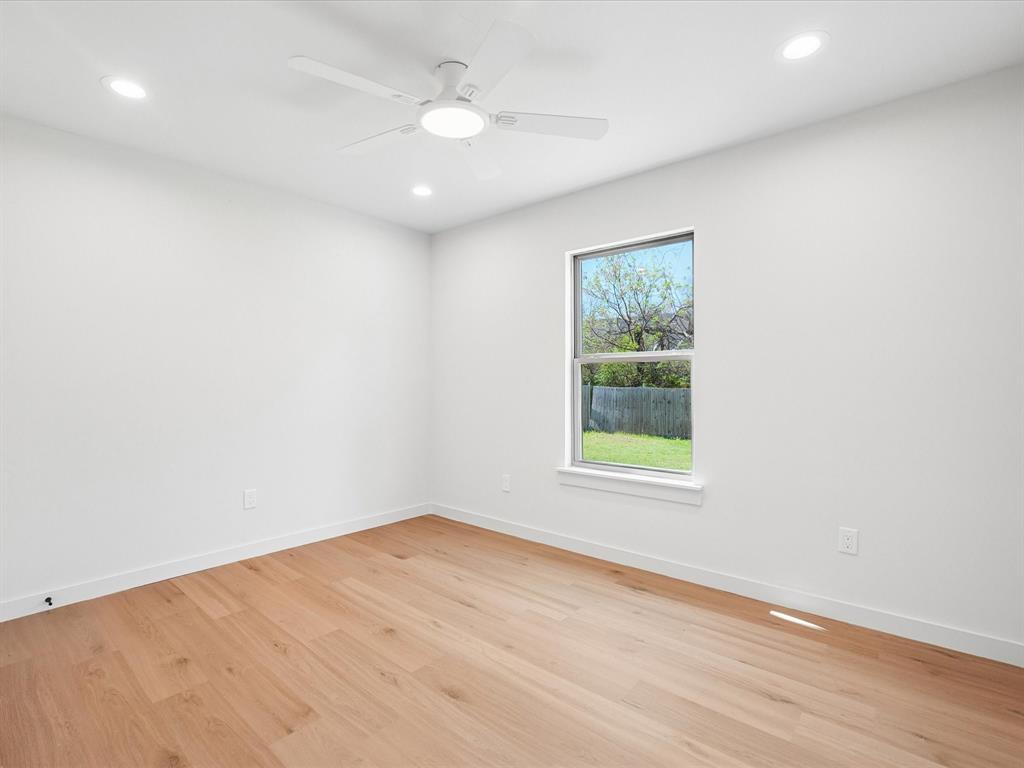 5544 Ranchero Lane Dallas, TX 75236 - Photo 14 of 21 an empty room with wooden floor and windows