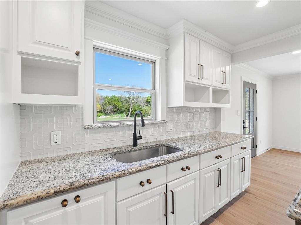 5544 Ranchero Lane Dallas, TX 75236 - Photo 8 of 21 a kitchen with granite countertop a sink window and cabinets