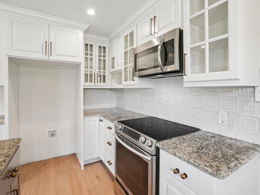 5544 Ranchero Lane Dallas, TX 75236 - Photo 9 of 21 a kitchen with stainless steel appliances granite countertop white cabinets and window