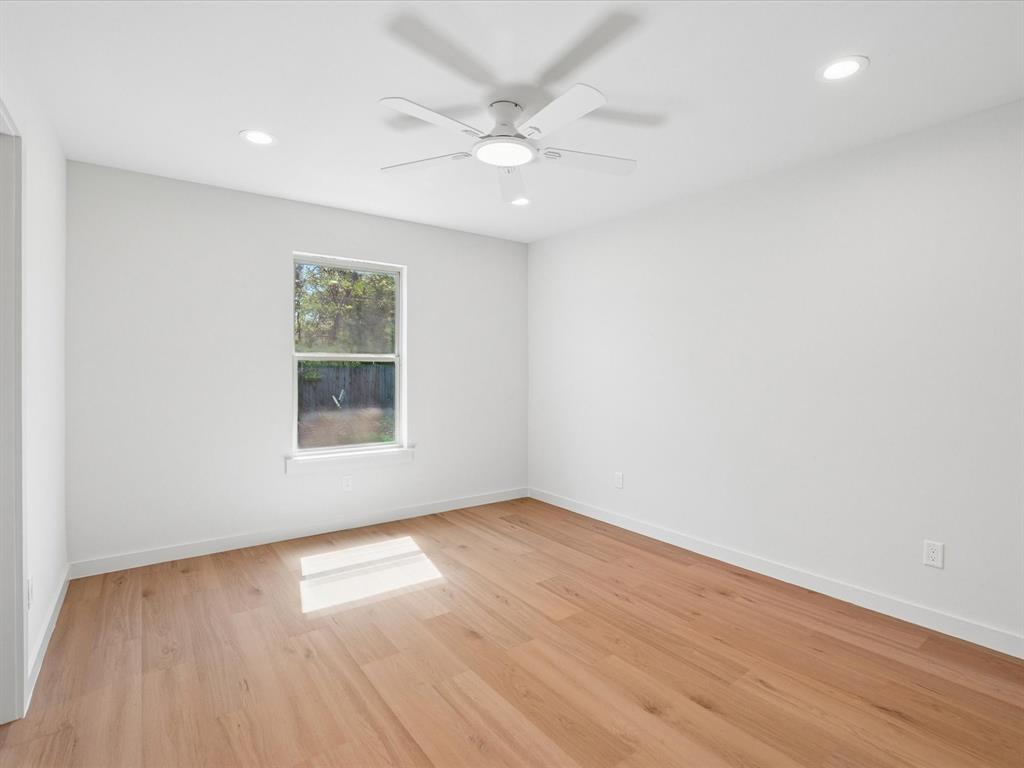 5544 Ranchero Lane Dallas, TX 75236 - Photo 10 of 21 an empty room with wooden floor and windows