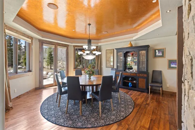 a view of a dining room with furniture a chandelier and wooden floor