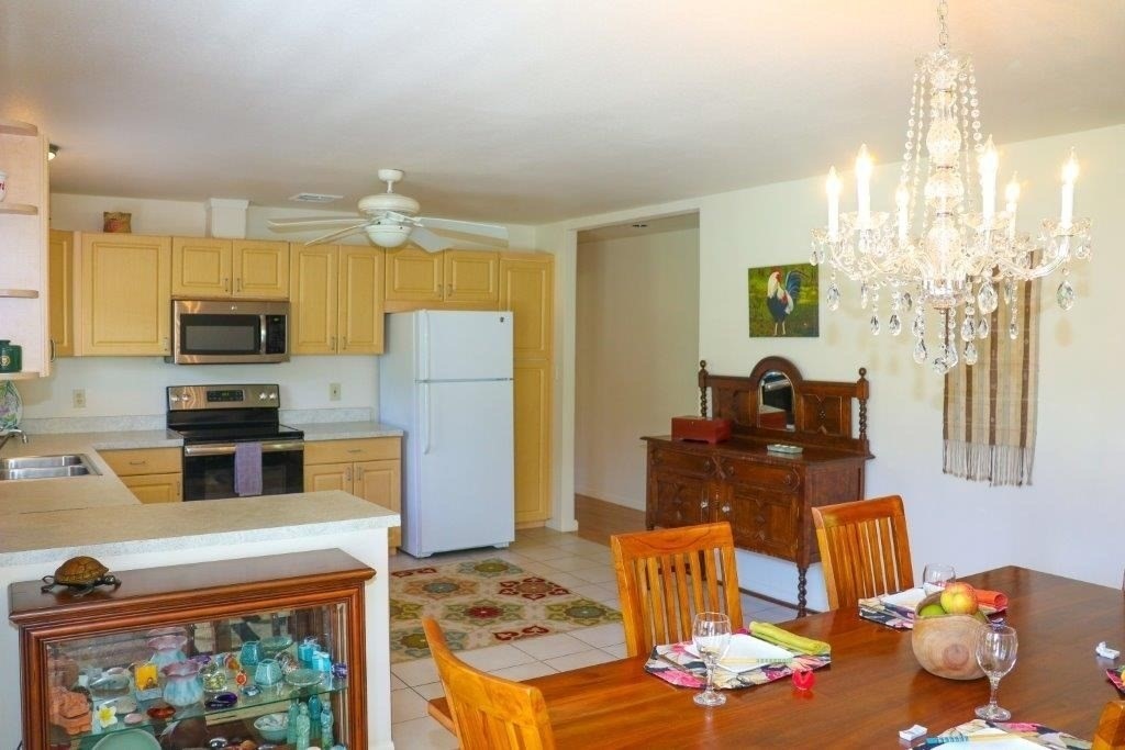 6671 Puupilo Road Kapaa, HI 96746 - Photo 10 of 24 a kitchen with stainless steel appliances wooden floor dining table and chairs