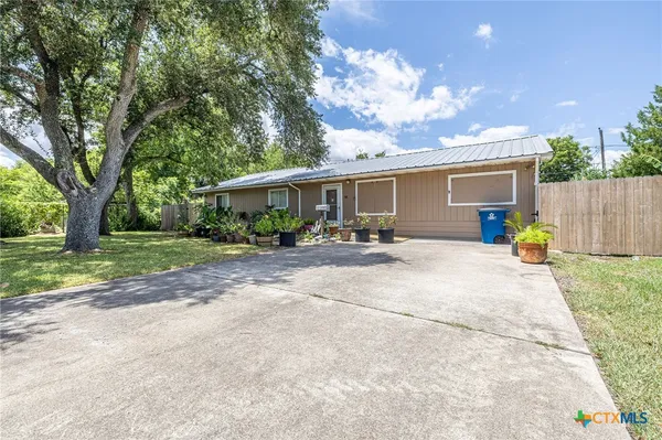 a view of a house with backyard and a tree