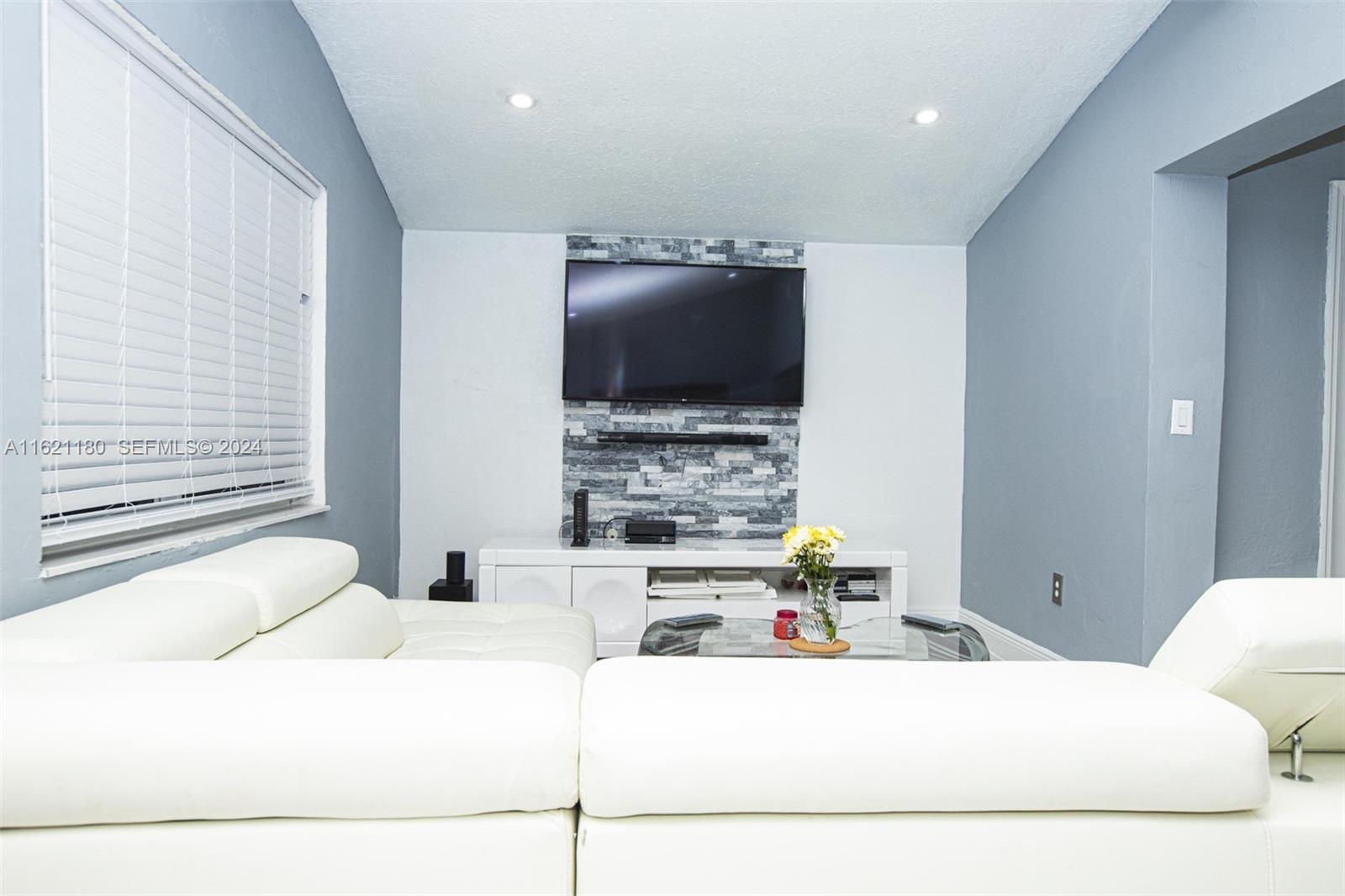 418 Northwest 47th Street Miami, FL 33127 - Photo 13 of 24 a living room with furniture and a flat screen tv
