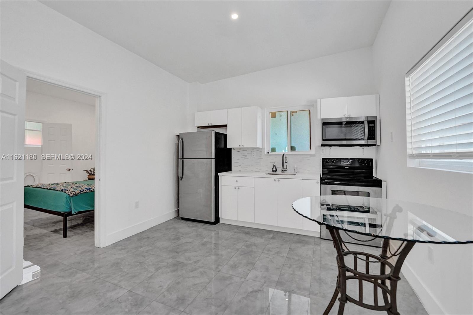 418 Northwest 47th Street Miami, FL 33127 - Photo 16 of 24 a kitchen with a refrigerator and a stove top oven