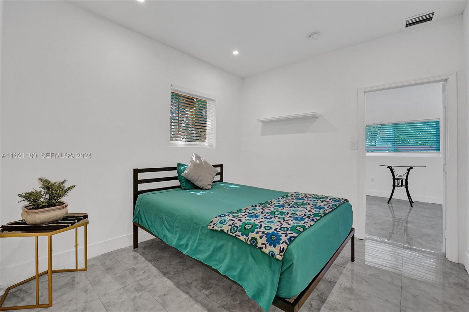 418 Northwest 47th Street Miami, FL 33127 - Photo 18 of 24 a bedroom with a bed windows and a potted plant