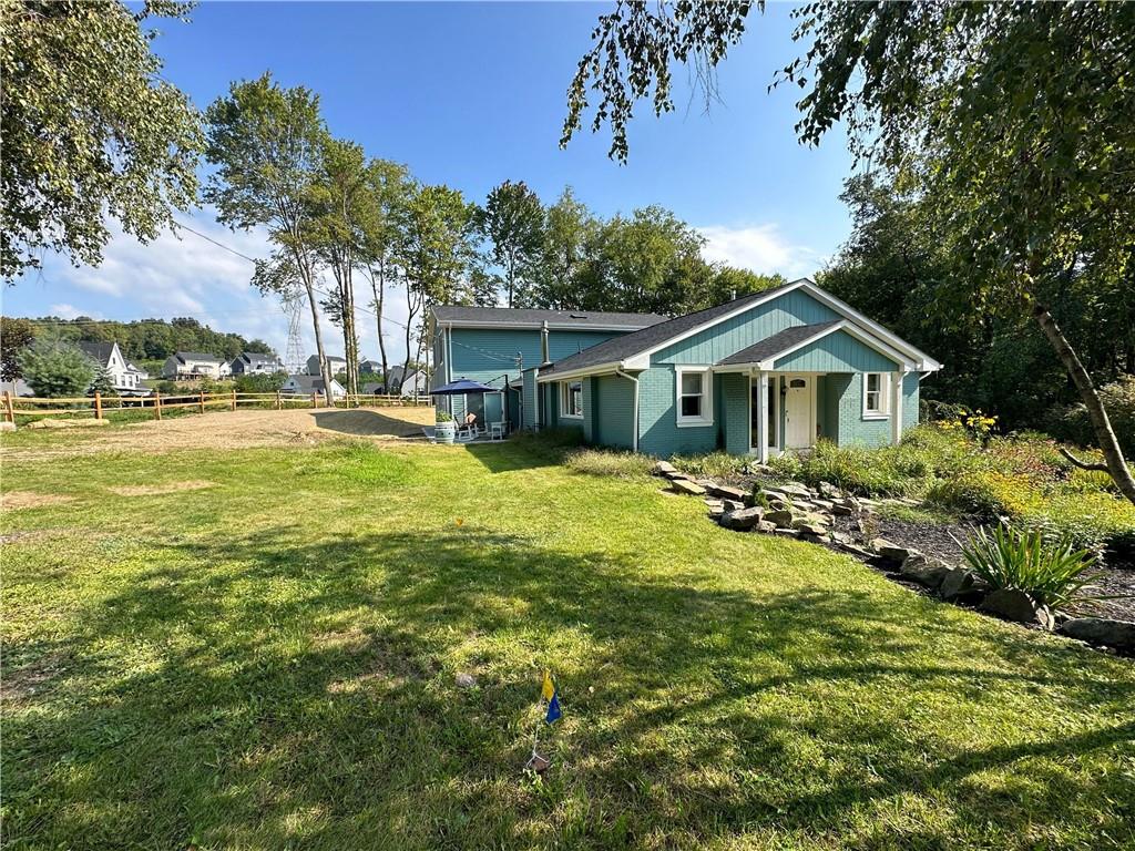 a view of a house with a yard and sitting area