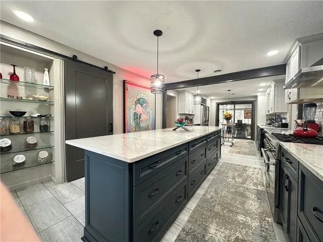 a large kitchen with granite countertop a lot of counter top space