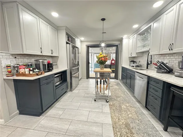 a kitchen with stainless steel appliances granite countertop a sink counter space cabinets and a rug
