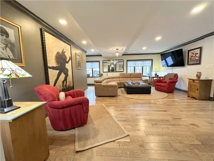 a bedroom with furniture a flat screen tv and a large window