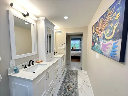 a bathroom with a sink a mirror a vanity and a shower