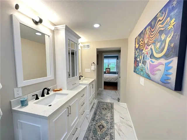 a bathroom with a sink a mirror a vanity and a shower