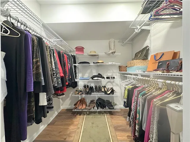 a view of walk in closet with clothes and shoes