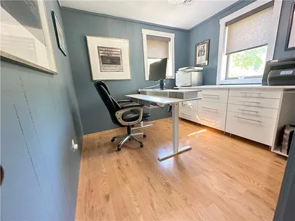 a view of a workspace with furniture and a window