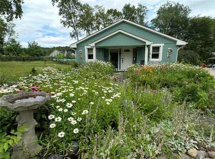 a front view of a house with a yard and potted plants