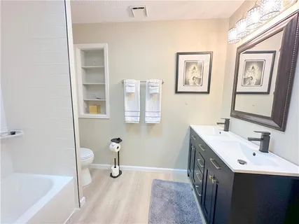 a bathroom with a tub sink and mirror