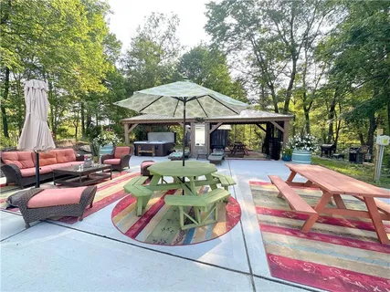 a view of a patio with couches table and chairs under an umbrella