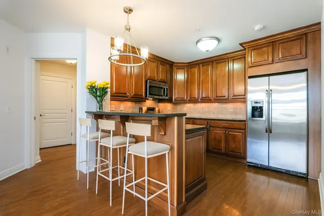 a kitchen with granite countertop stainless steel appliances a stove top oven a sink a counter space and cabinets