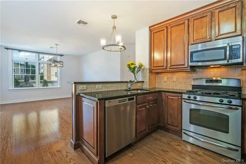 a kitchen with stainless steel appliances granite countertop a stove a sink and a microwave