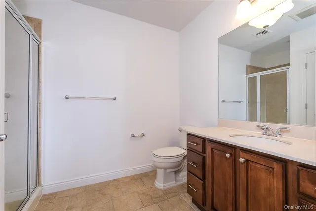 a spacious bathroom with a sink a toilet a mirror and a shower