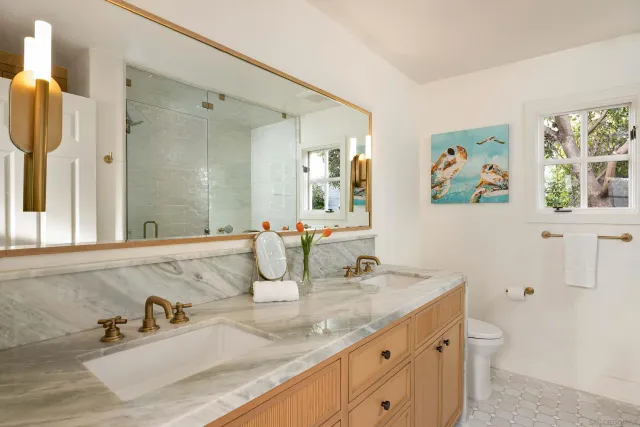 a bathroom with a granite countertop sink a large mirror a shower and a bathtub