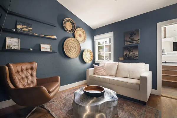 a living room with furniture and a wall painting