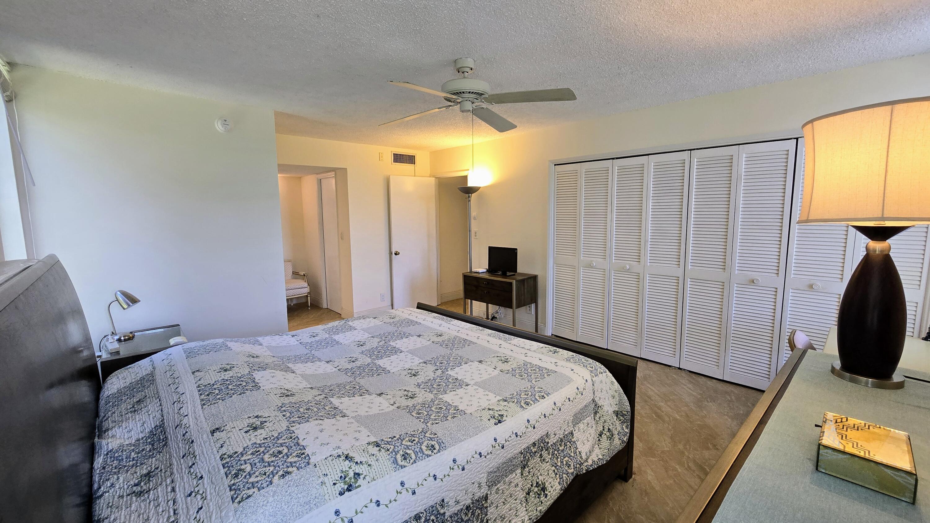 3100 North Course Lane, Unit 410 Pompano Beach, FL 33069 - Photo 14 of 23 a bedroom with a bed and a flat tv screen on dresser