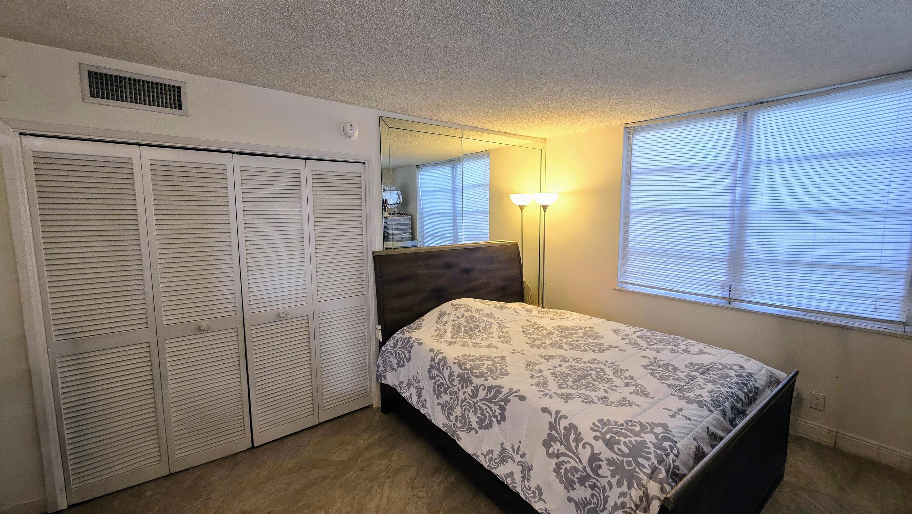 3100 North Course Lane, Unit 410 Pompano Beach, FL 33069 - Photo 18 of 23 a bedroom with a bed and wooden floor