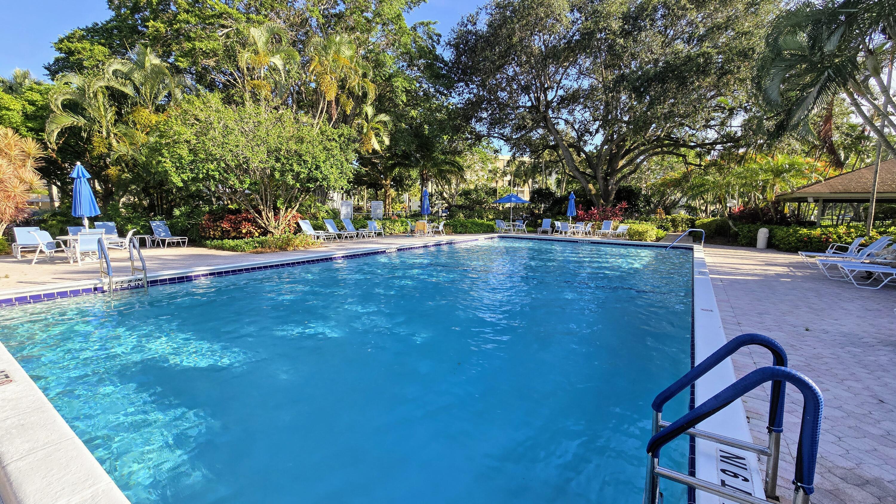 3100 North Course Lane, Unit 410 Pompano Beach, FL 33069 - Photo 21 of 23 a backyard of a house with table and chairs