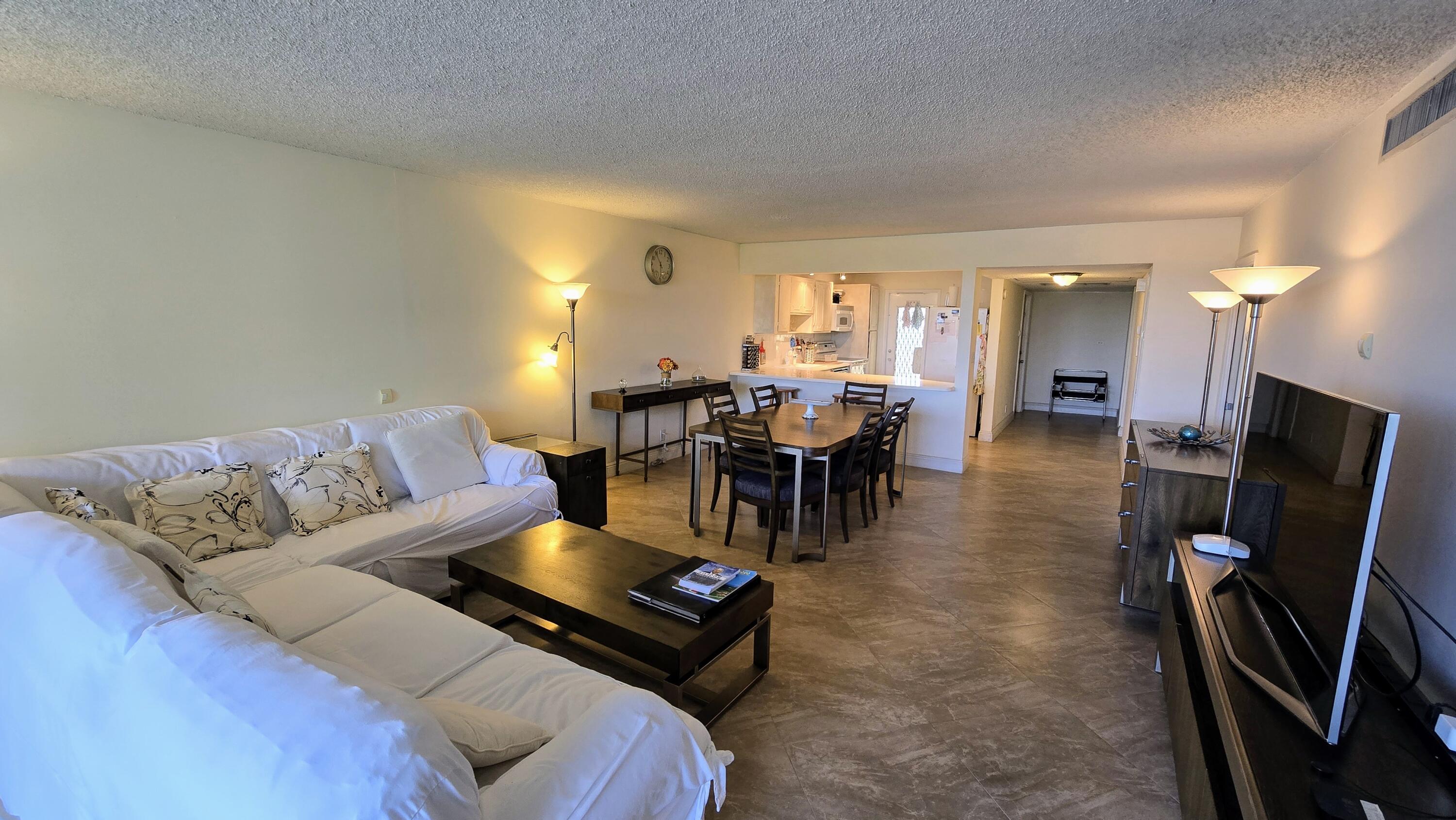 3100 North Course Lane, Unit 410 Pompano Beach, FL 33069 - Photo 7 of 23 a living room with furniture a dining table and a flat screen tv