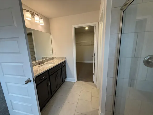 a bathroom with a granite countertop sink toilet mirror and bathtub