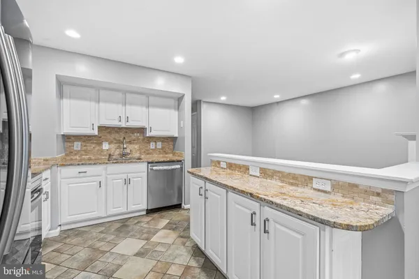 a kitchen with granite countertop sink and cabinets