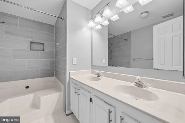 a bathroom with a tub a sink and a mirror