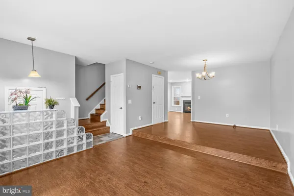 a view of an empty room with wooden floor and a fireplace