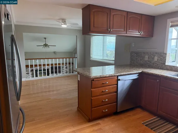 a kitchen with granite countertop wooden cabinets and entryway