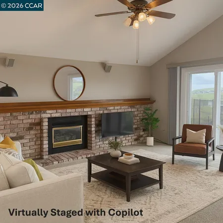 a living room with furniture a fireplace and a large window