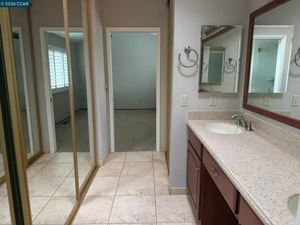 a bathroom with a granite countertop sink a mirror and a shower