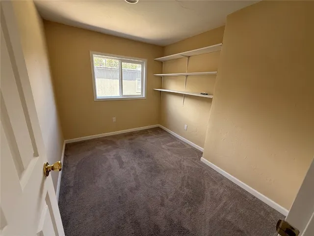 an empty room with windows and closet